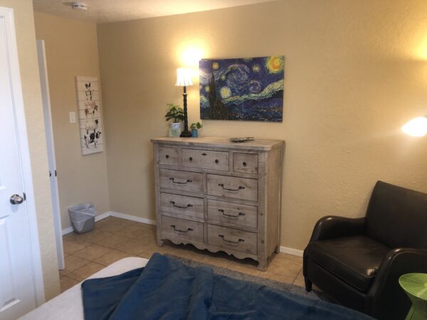 Alamo Apartment A Cozy bedroom with distressed dresser and starry night print