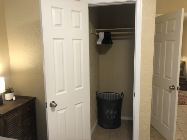 Alamo Apartment A Bedroom closet with laundry basket