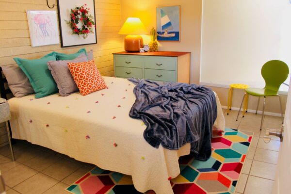 vintage dwelling colofrul bedroom with stacks of pillows and geometric rug