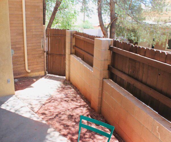 vintage dwelling Back patio with wooden and brick fence and blue patio furniture